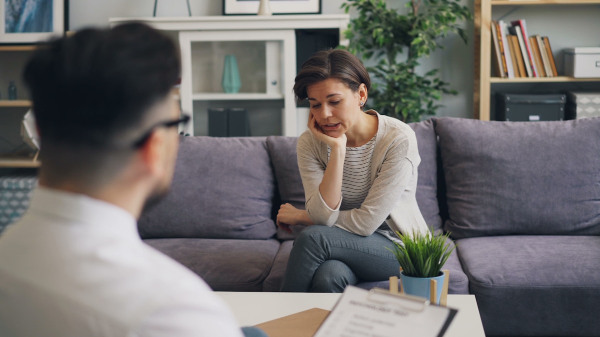 A therapist and client talking on a couch