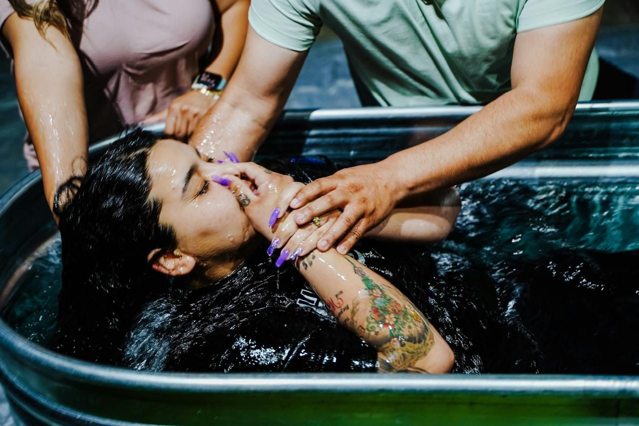 A person lowered into an ice bath, held by others