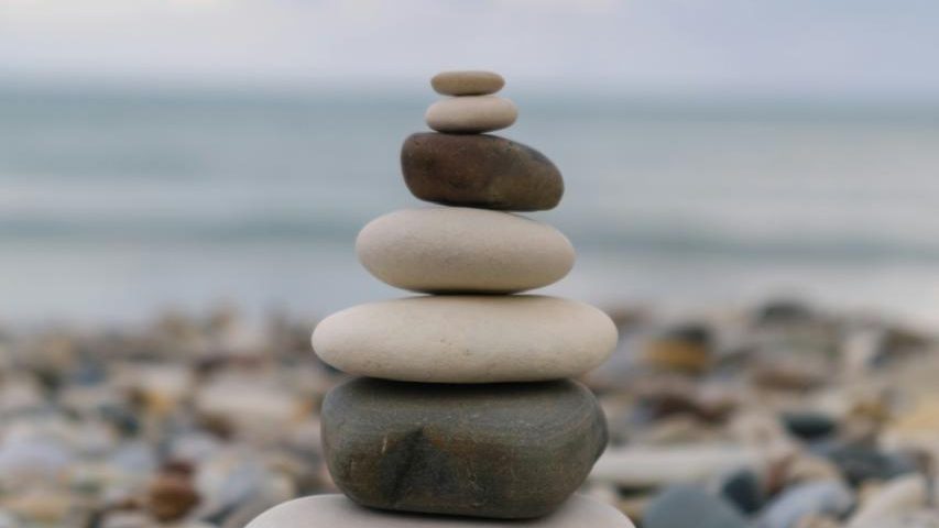 Smooth stones balanced in a stack on a pebble beach