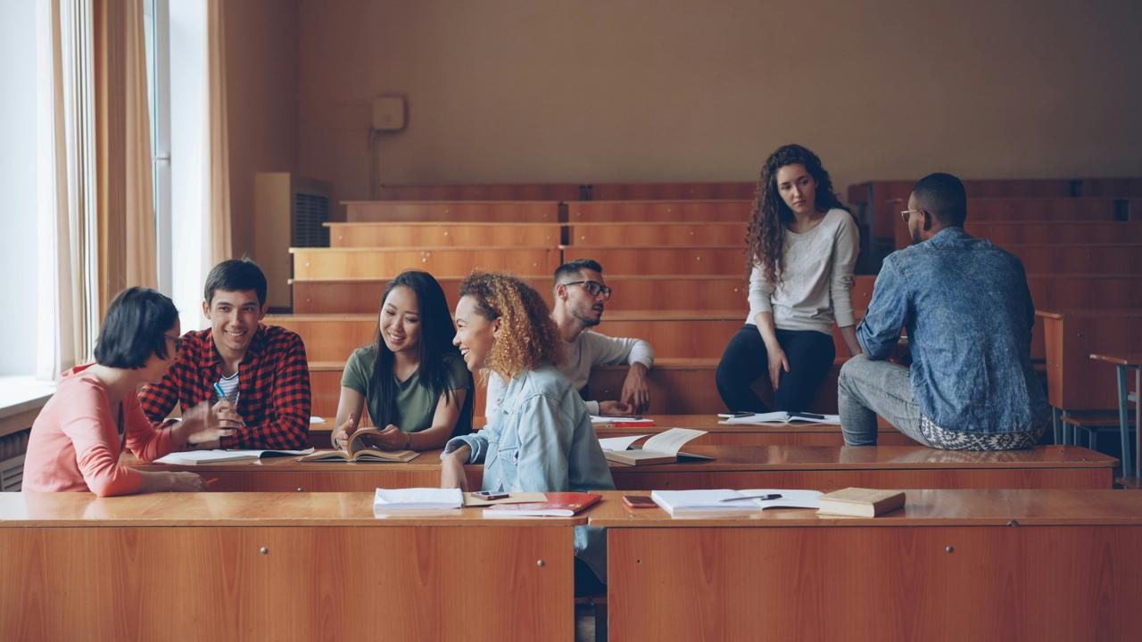 Students talking together across lecture hall desks