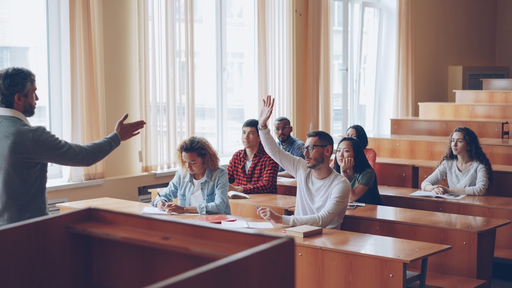 Students raising their hands in a lecture hall