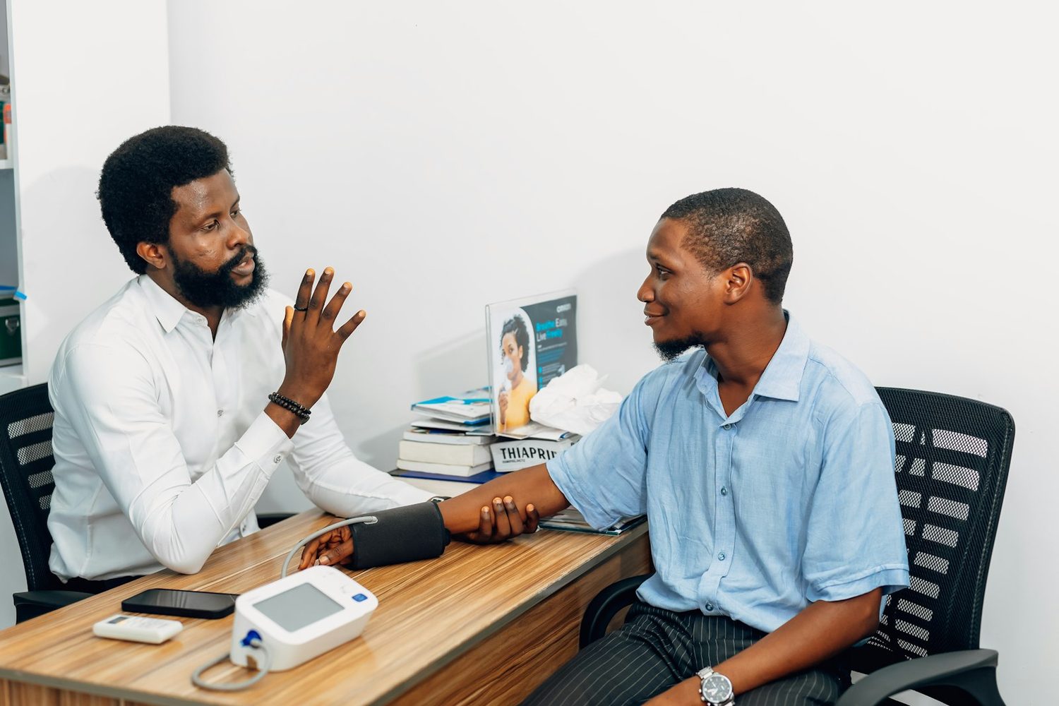 A doctor in conversation with a patient across a desk
